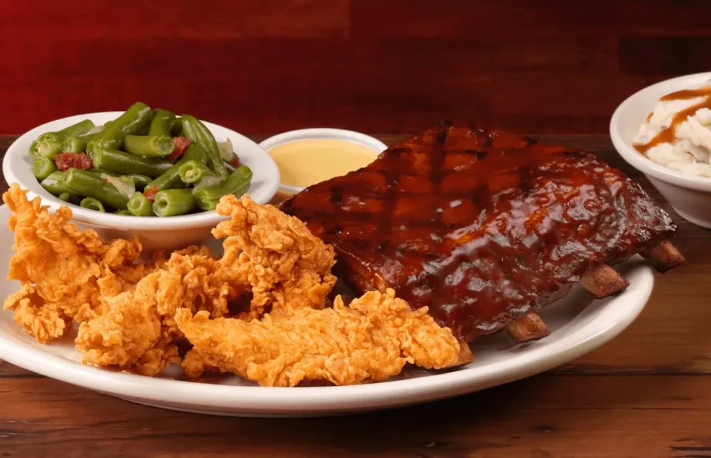 A pair crispy chicken and half slab of juicy ribs with green beans and sauce on the side 