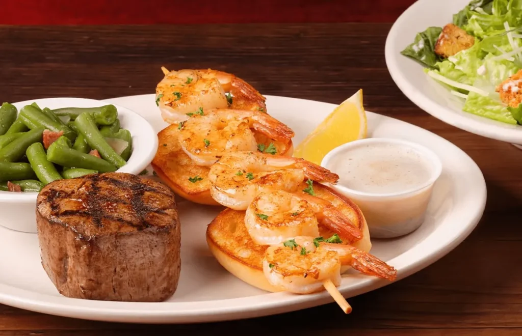 Grilled Shrimp and filet served with green beans and dip sauce wih lemon