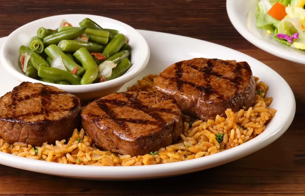 8 oz Filet Mignon served with rice and green beans on a plate