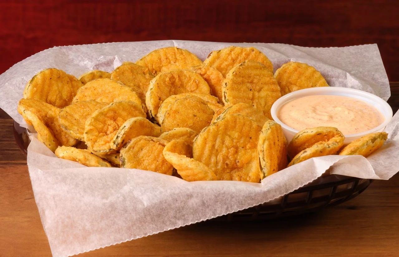 Golden fried pickles in a basket, served with creamy ranch dip