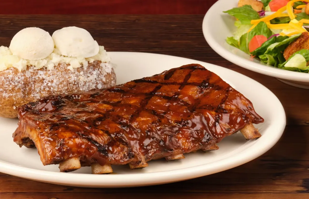 Half slab of ribs served with the baked potato 