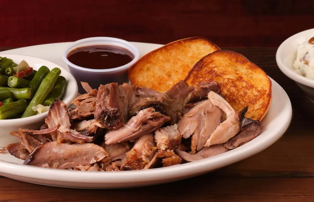 pulled pork dinner with sauce and green beans served a side