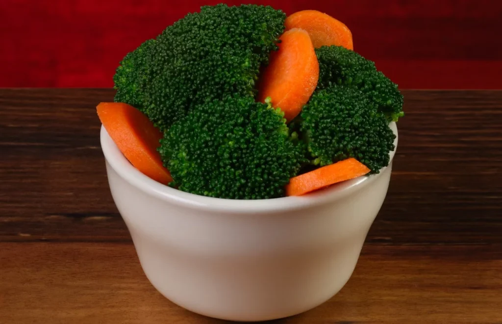 A bowl full of fresh green broccoli and sweet carrot 