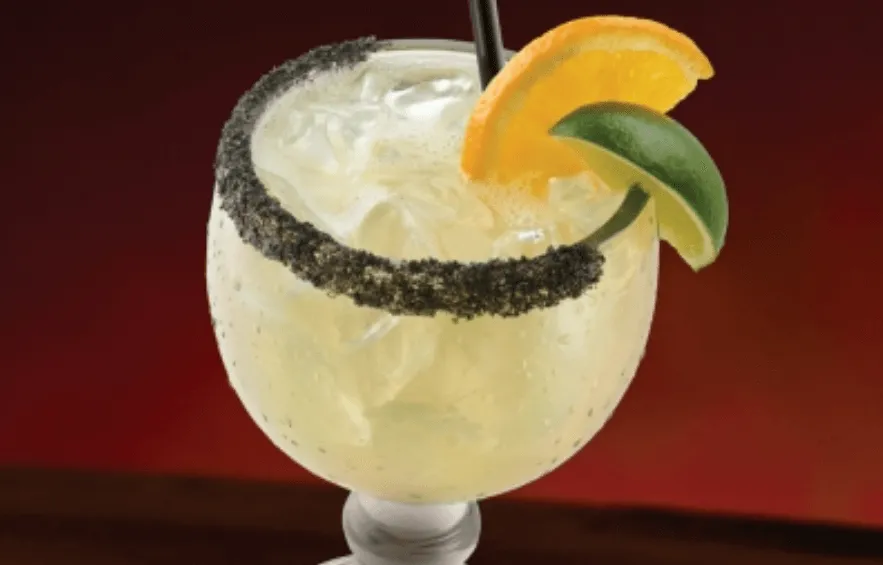 The legend margarita in glass with ice and lemon garnish
